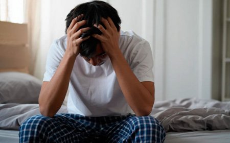 Мужчина сидит на кровати